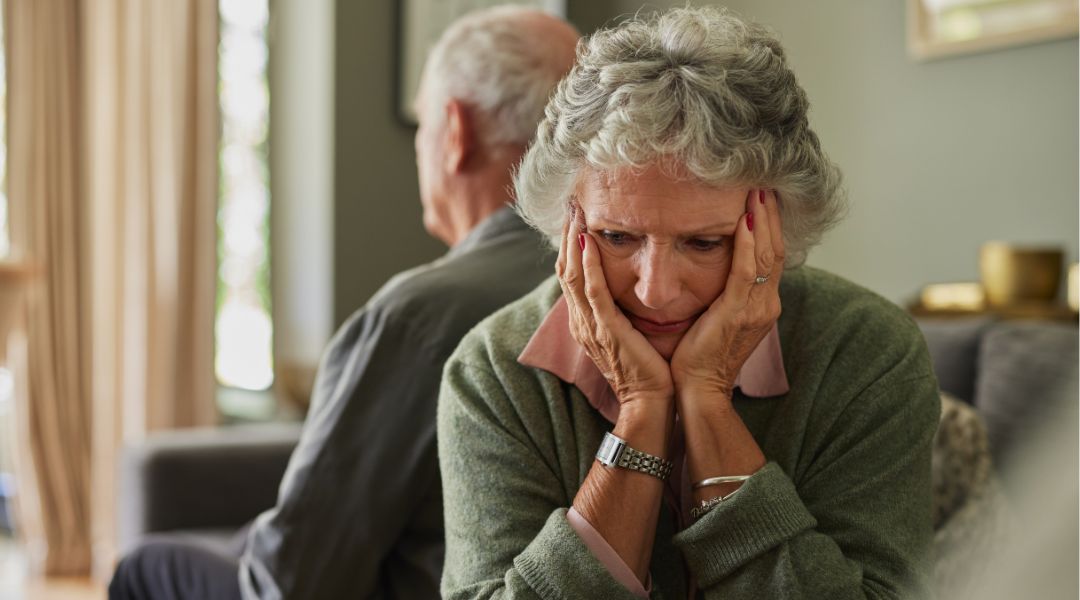 Older couple sitting with their backs to each other and the woman is unhappy - understanding gray divorce in Michigan - Stephanie Krane-Boehmer Law.