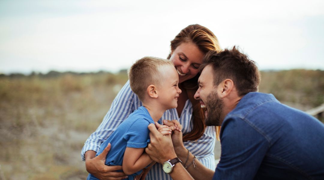 Couple with child outdoors, smiling - Michigan custody laws for unmarried parents - Stephanie Krane-Boehmer Law.