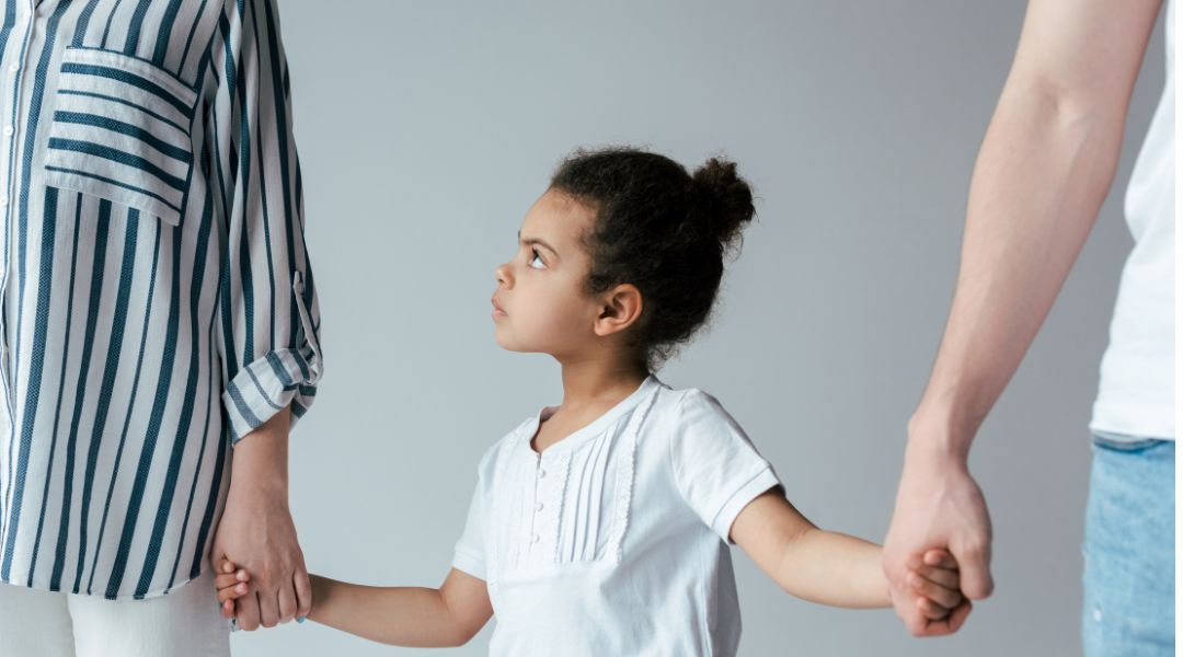Child held by her hands by separated parents - child custody in Michigan - Stephanie Krane Law.